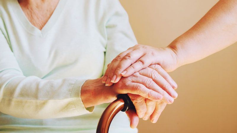 Hands holding with walking stick