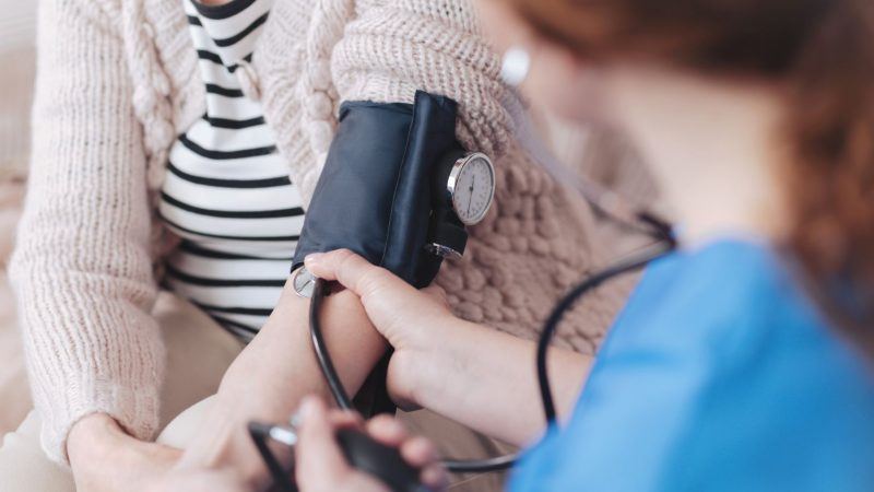 Nurse taking blood pressure of patient