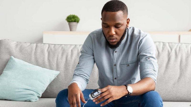 Black gentleman testing his blood oximetry at home